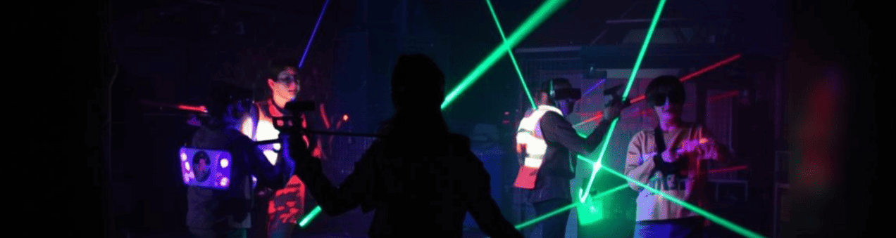 Afbeelding met jongeren die aan het lasergamen zijn.